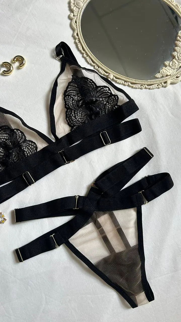 Detalle de encaje floral negro sobre tul nude semitransparente