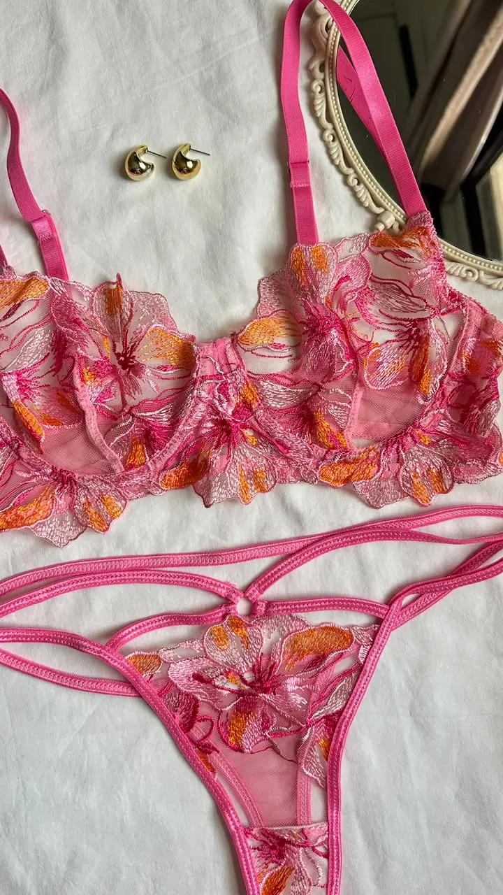 Detalle de las flores bordadas en rosa y naranja sobre malla transparente del conjunto Adara